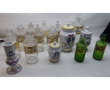 Nine clear glass Chemist's Jars with black and gilt labels, two green glass jars, and four modern ceramic drug jars.