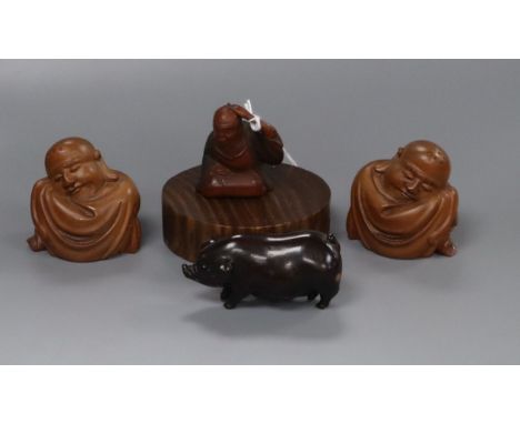 A 19th century Japanese wood netsuke of a seated man together with three carved wood figures 4cm - 6cm