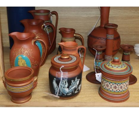 A collection of Etruscan-style redware, including a black-figured bottle-shaped vase, a similar jug, two graduated jugs with 