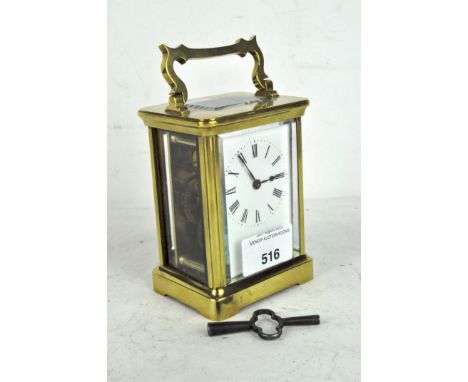 A 20th century carriage clock, 8 day movement, white enamel dial with Roman numerals contained in brass case with bevelled gl