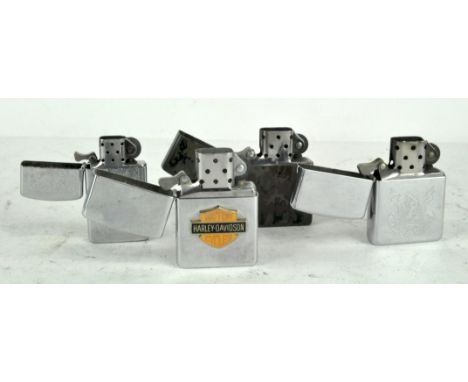 Four Zippo lighters, including a 'Harley-Davidson Motor Cycles' and a 'Zippo Classic' example