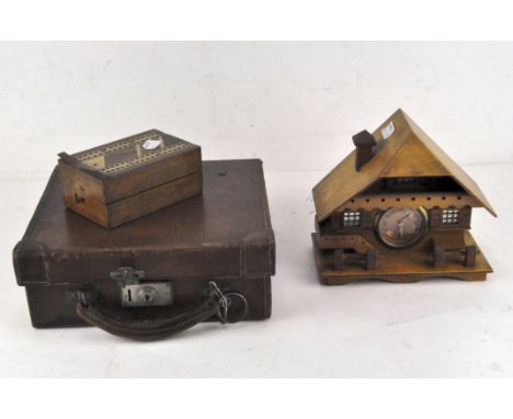 A small mid century leather travel case, of square form, containing a novelty mantel clock in the form of a house and a trave