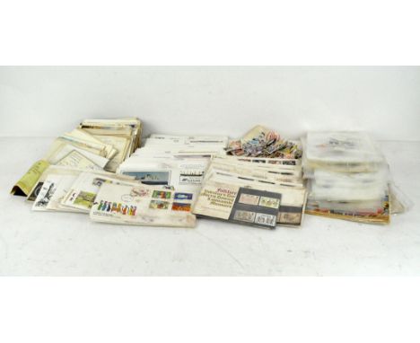A collection of stamps and postcards, first day editions, some loose in packets, worldwide 