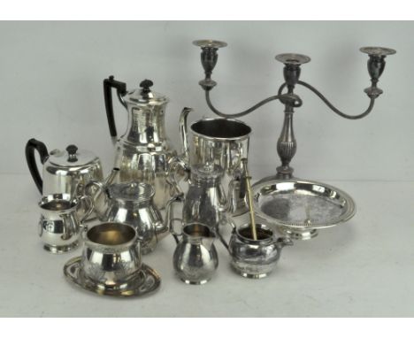 A large selection of silver plate to include a wine bottle stand, tea sets, candelabra, decanter and other pieces