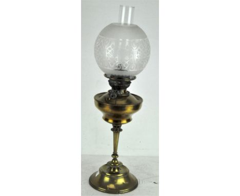 A Victorian oil lamp, with decorated glass shade, clear chimney and clear glass reservoir, supported on a brass circular base