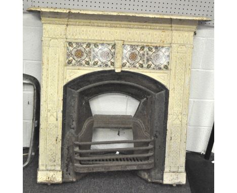 An Edwardian cast iron fire surround, grate and mantel, the surround and mantel painted cream, to each side a crossed torch m