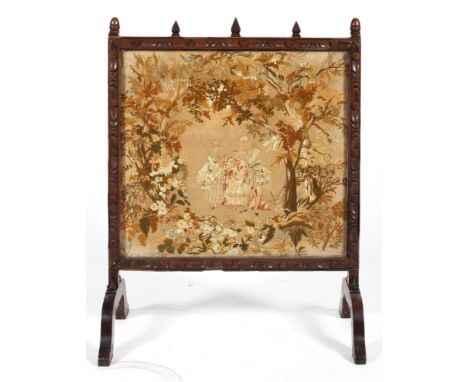 A 19th century oak fire screen with tapestry insert, the frame carved with ovolos and  spire finials and the tapestry woolwor