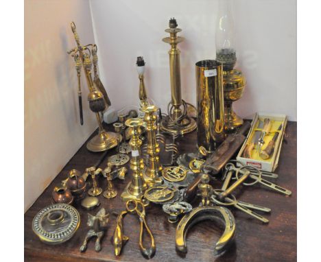 A large collection of brassware including a pair of brass candlesticks, door knocker modelled as a fox, oil lamp, horse brass