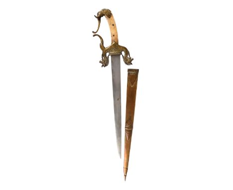 A South Indian dagger, tapering single-edged blade 11 in.; ornate brass hilt with down-turned quillons in the form of boars' 