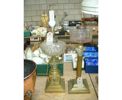 A Victorian brass Corinthian column oil lamp and a second brass oil lamp with a stepped plinth base the plinth mounted with w