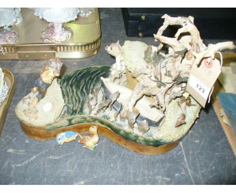 A Pottery group, boat beneath a tree trunk with figures, stamped Brian Holdcroft.