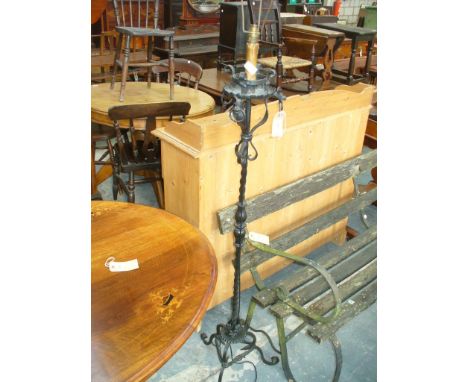 An Ornate wrought iron lamp standard  raised on a triform base.