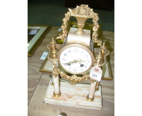 A late 19th Century onyx and gilt metal mantle clock, the flat plinth base raised on gilded terminals, extending to four colu