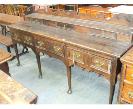 A rare mid 18th Century and later oak dresser, the scroll cut low back above a single shelf and three small frieze drawers ab