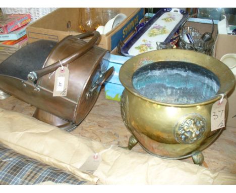 An Antique copper coal helmet and a brass jardinere with paw feet and decorated in relief with lion masks. (2)