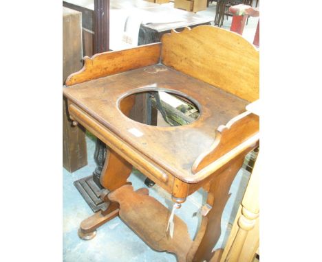 A Victorian mahogany wash stand
The galleried rectangular top centred with a circular aperture, raised on vase shaped bracket