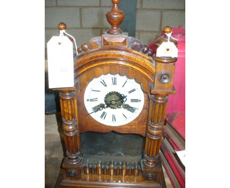 A late 19th Century walnut alarm mantle clock
The Gothic architectural casing with three campana urn finials, the hinged and 