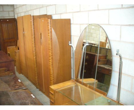 A Mid 20th Century art deco bedroom suite comprising ladies and gents wardrobes, a dressing table with a large oval mirror, h