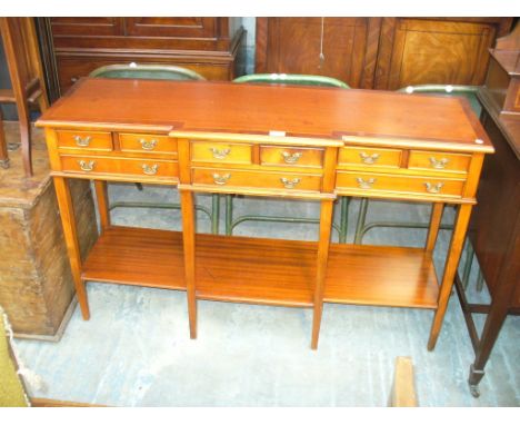 A Reproduction mahogany breakfront sideboard with an arrangement of nine small drawers above an under shelf.