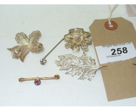 An amethyst and seed pearl brooch
To yellow metal, together with, three white metal filigree brooches and a paste stick pin (