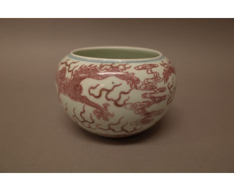 A Chinese porcelain compressed circular vase, blue six-character Kangxi mark but later, painted in underglaze-red and blue wi