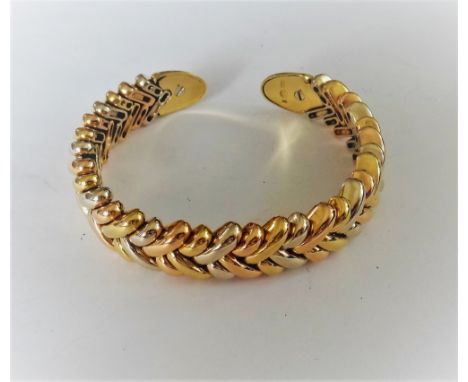 A three colour gold bangle, in a large and small slanting link design, with yellow gold terminals, detailed 750, gross weight