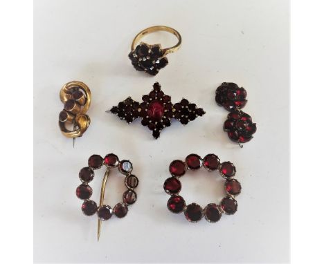 A foil backed flat cut garnet set brooch, in an openwork design, a similar garnet set brooch, (the pin lacking), two further 