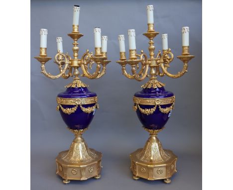 A pair of Louis XVI style porcelain and gilt metal mounted five branch candelabra, modern, each cobalt blue urn issuing five 