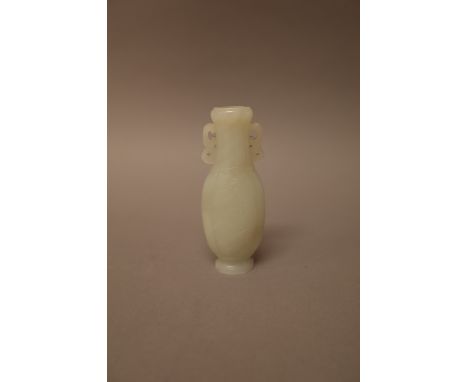 A Chinese pale celadon jade slender ovoid two handled flask, each side carved in low relief with a panel of flowers, 10.5cm. 