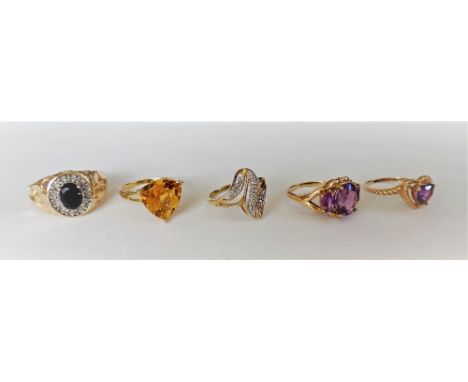 A gold and amethyst three stone ring, claw set with a row of oval cut amethysts, detailed 10 K, a gold and citrine single sto