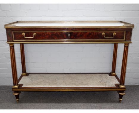 An early 19th century French brass mounted mahogany console, the galleried marble top over frieze drawer on fluted columns un