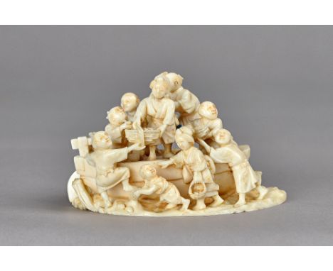 A Japanese ivory group of figures and a boat, Meiji period, carved with five men woman in the boat carrying baskets of provis