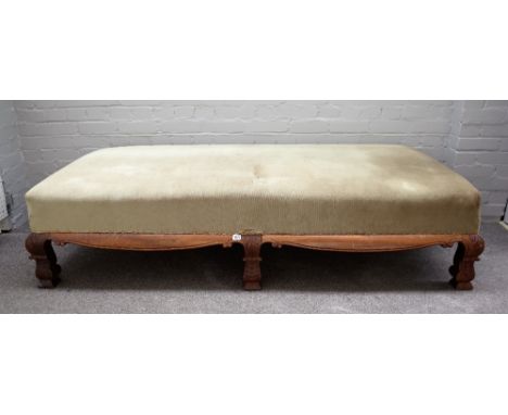 A late 19th century walnut framed rectangular footstool with shaped frieze on six scale carved block supports, 187cm wide x 4