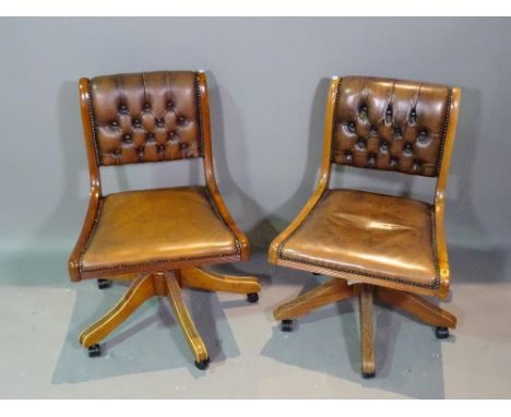 A pair of 20th century mahogany office chairs with faux green leather button back upholstery, (2). 