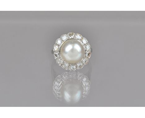 A white gold and platinum, cultured pearl and diamond cluster ring, mounted with the single cultured pearl at the centre, in 