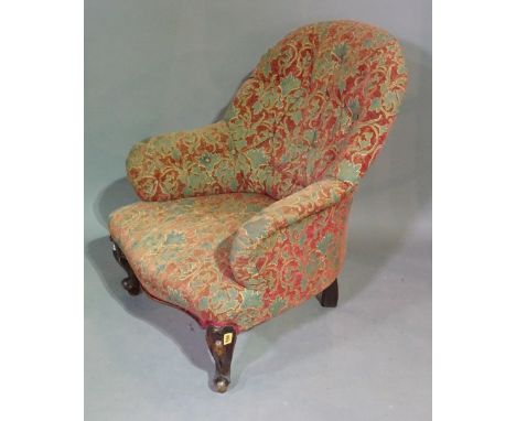 A Victorian mahogany framed low armchair with button back upholstery on scroll supports. 