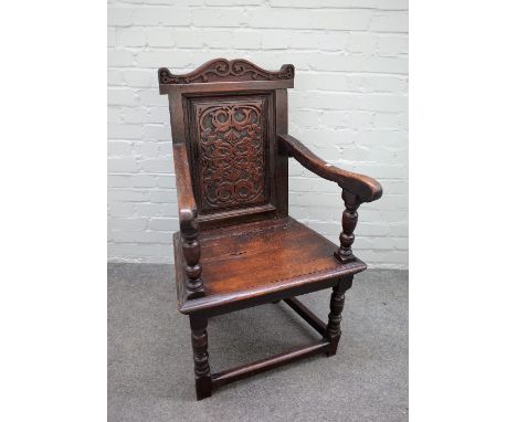 A 17th century walnut Wainscot open armchair with carved panel back on turned supports, united by perimeter stretcher, 62cm w