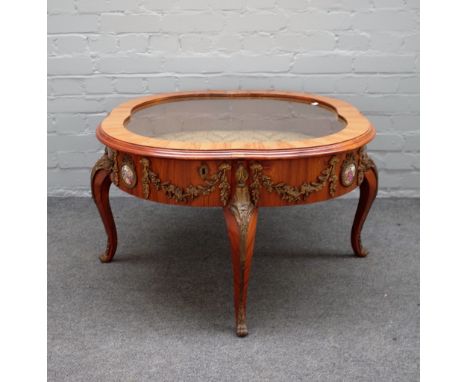 An 18th century style French gilt metal and ceramic mounted kingwood coffee/bijouterie table with shaped glazed hinged top on