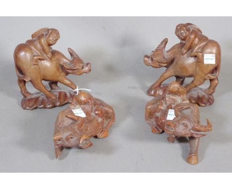 Four Chinese wood figures of boys seated on water buffaloes, 20th century.  