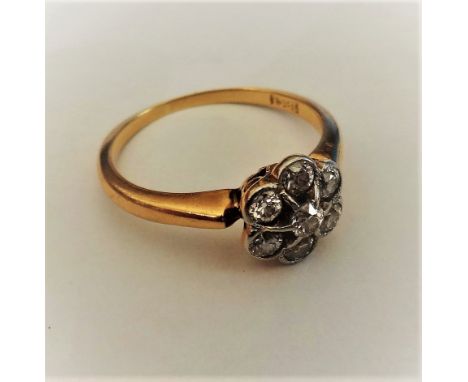 A gold and diamond set seven stone cluster ring, mounted with circular cut diamonds, detailed 18 CT, ring size L.