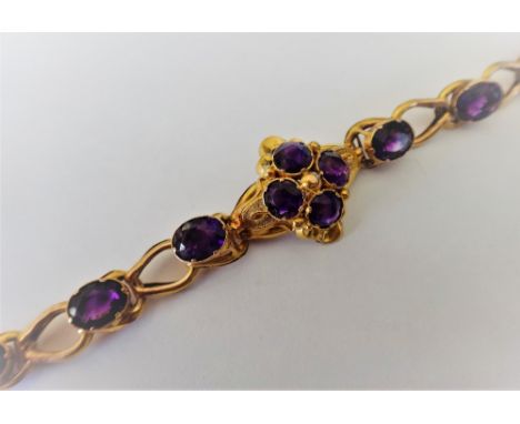 A Victorian gold and amethyst bracelet, the centre with a four stone cluster, mounted with cushion shaped amethysts, the link