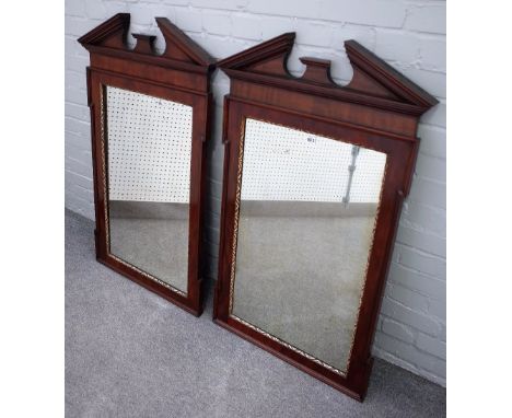 A pair of George II style parcel gilt mahogany pier glasses, each with broken architectural cornice above in-stepped rectangu