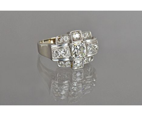 A white gold and diamond set cocktail style ring, mounted with the principal cushion shaped diamond to the centre and otherwi