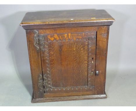 A 17th century oak hanging cupboard, the single panel door with dog tooth decoration, 76cm wide x 80cm high x 34cm deep.