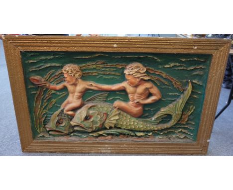 A polychrome painted rectangular panel, early 20th century, relief moulded plaster on pine depicting two putto riding mytholo
