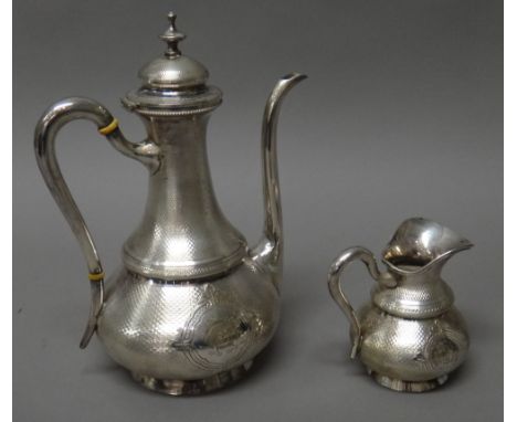 A French coffee pot, with a matching milk jug, each piece of baluster form, with engine turned decoration, monogram engraved 