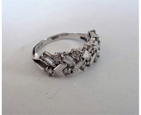 An 18ct white gold and diamond half hoop ring, mounted with rows of alternating baguette and circular cut diamonds, in a slan