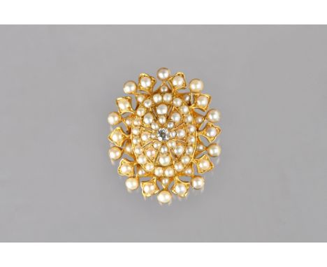 A Victorian gold, diamond and half pearl set oval brooch, mounted with the cushion shaped diamond at the centre and otherwise