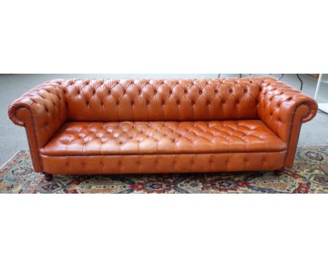 A large brown leather button upholstered Chesterfield sofa on turned feet, 255cm wide x 81cm high x 86cm deep. 