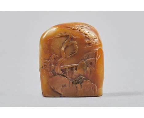 A Chinese brown soapstone boulder seal, Qing Dynasty, carved on one side with two figures crossing a bridge, the reverse with